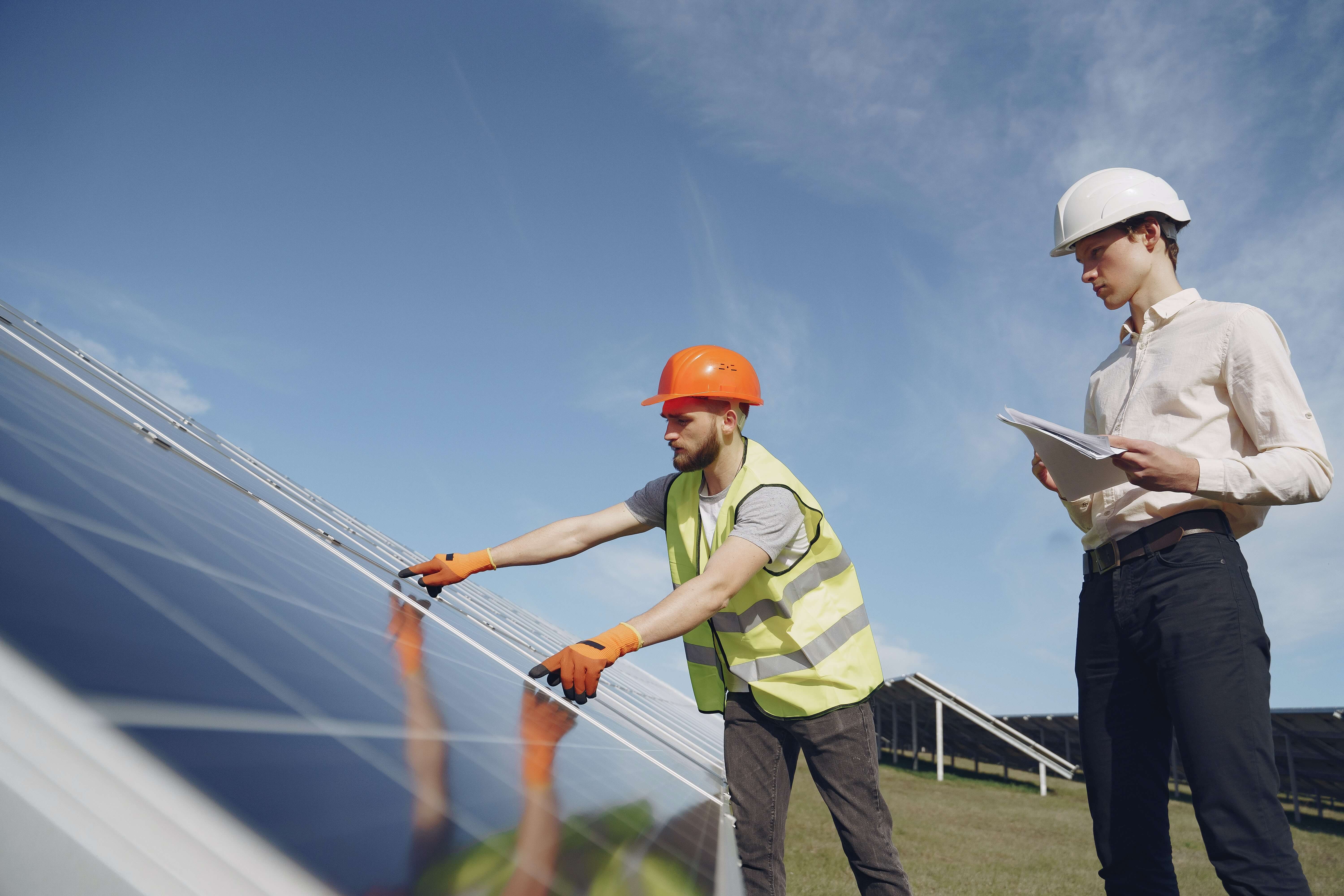 deux travailleurs devant un panneau solaire, été